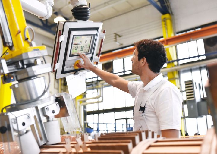 Engineer operates control panel in a manufacturing facility, the use of electronic product design services in automation.